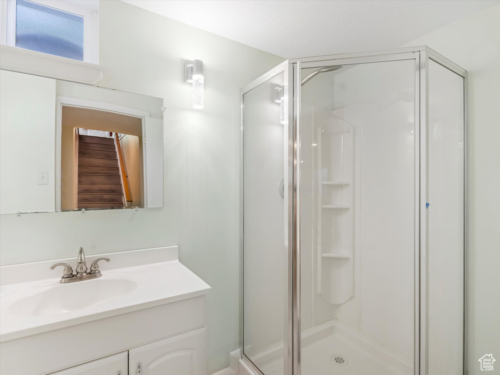 Full bathroom featuring a shower stall and vanity