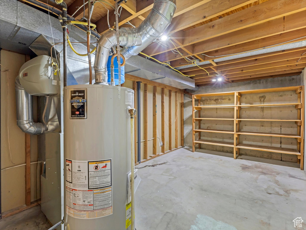 Unfinished below grade area featuring gas water heater