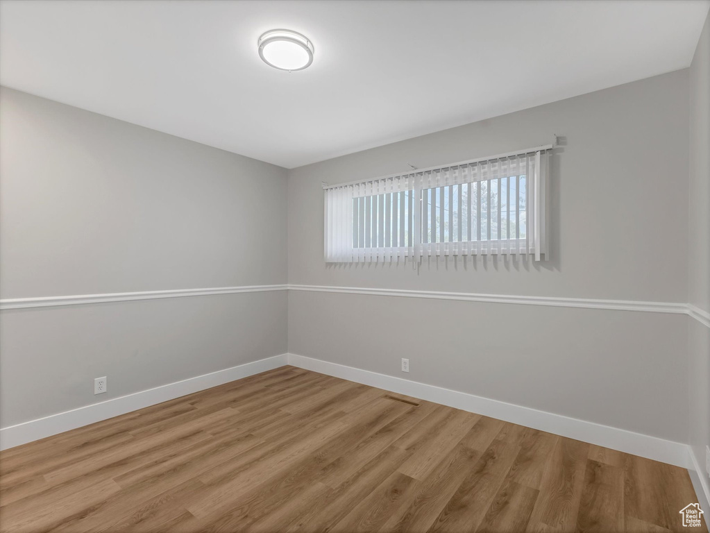 Unfurnished room featuring baseboards and wood finished floors