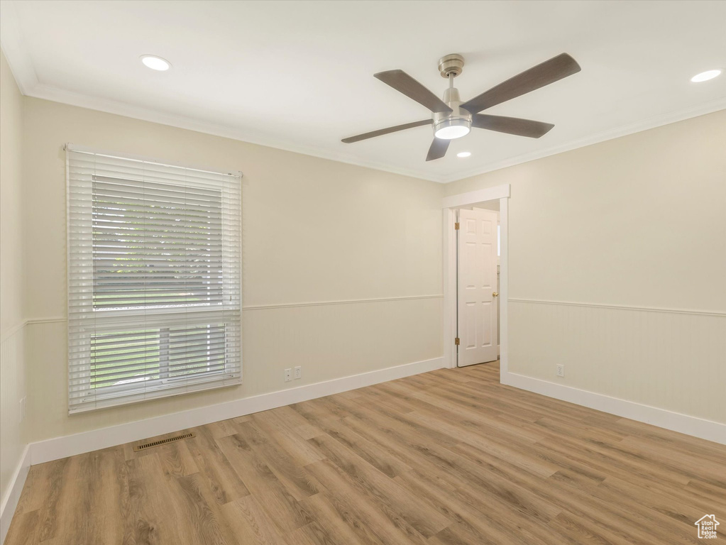 Spare room featuring wood finished floors, crown molding, recessed lighting, ceiling fan, and baseboards