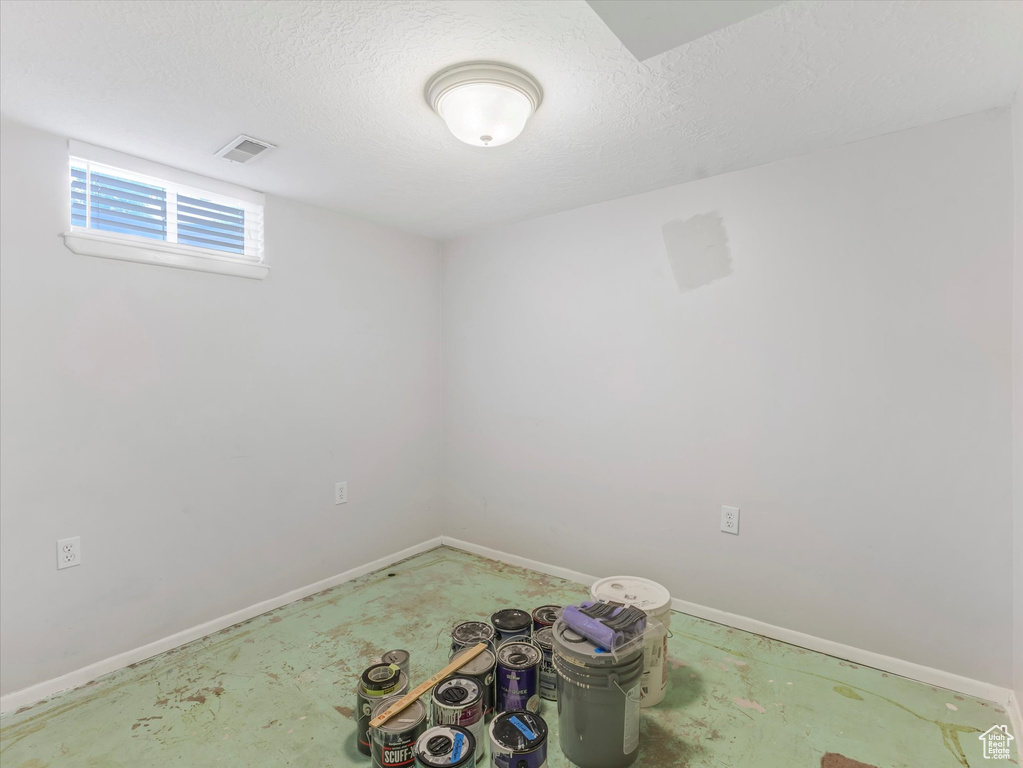 Empty room with baseboards and a textured ceiling