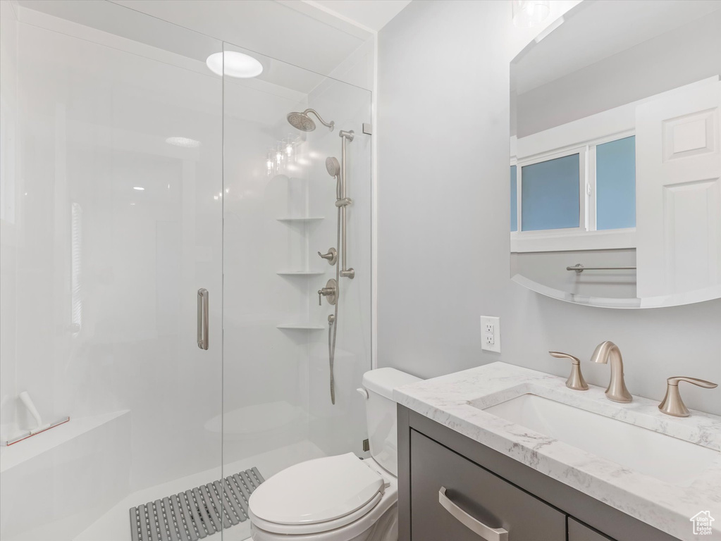 Bathroom with a stall shower, toilet, and vanity