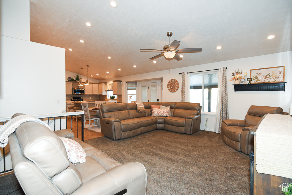 Living room featuring recessed lighting, ceiling fan, plenty of natural light, and dark colored carpet