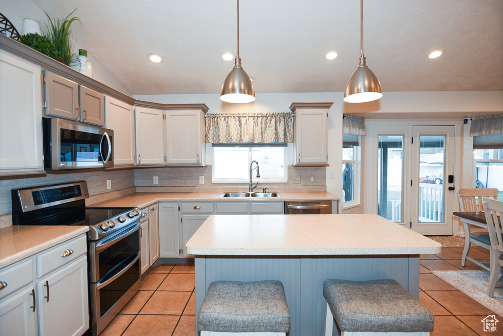 Kitchen with appliances with stainless steel finishes, a sink, healthy amount of natural light, decorative backsplash, and recessed lighting