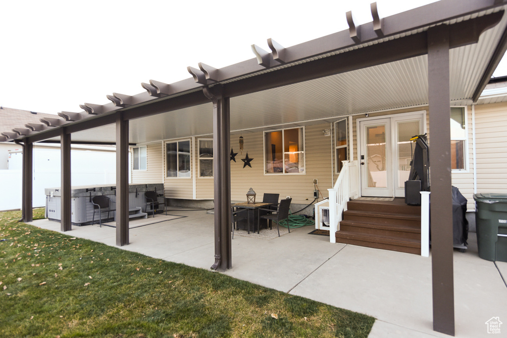 Rear view of property featuring entry steps and a lawn