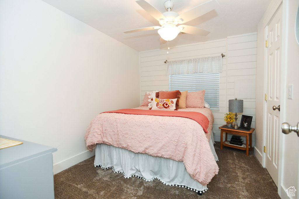 Carpeted bedroom featuring a ceiling fan and baseboards