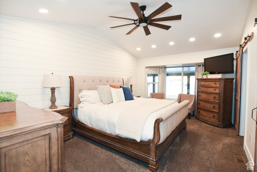 Bedroom featuring a barn door, vaulted ceiling, recessed lighting, dark colored carpet, and ceiling fan