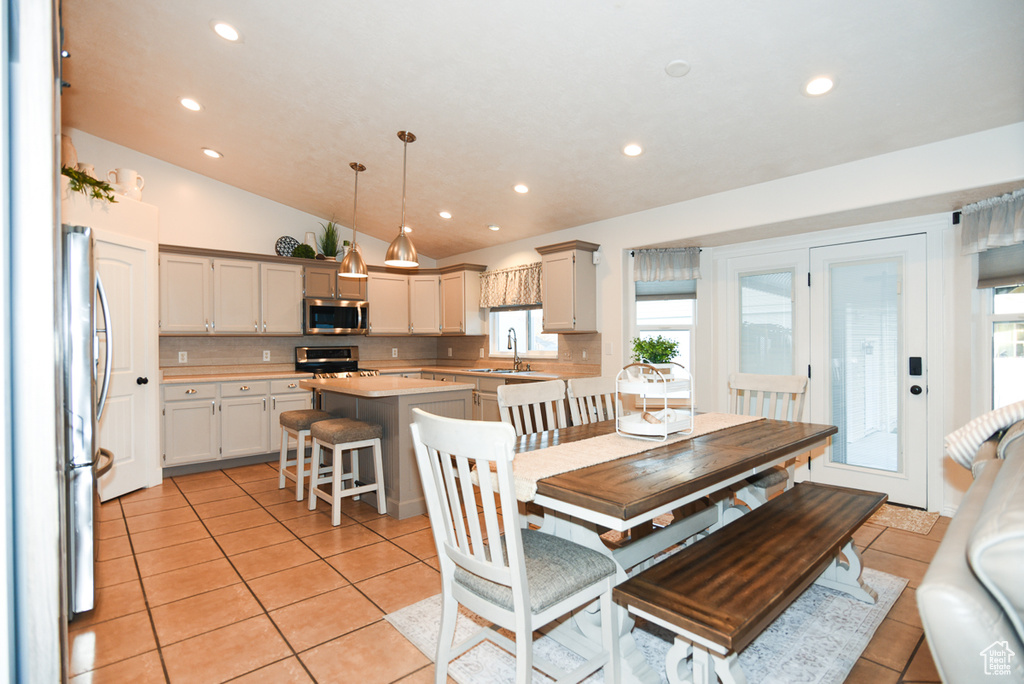 Dining room featuring light tile patterned floors, vaulted ceiling, recessed lighting, and plenty of natural light