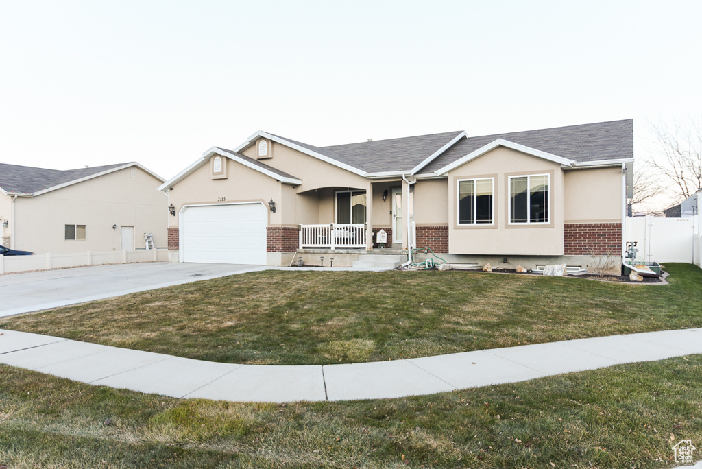 Single story home featuring covered porch, brick siding, concrete driveway, stucco siding, and a garage