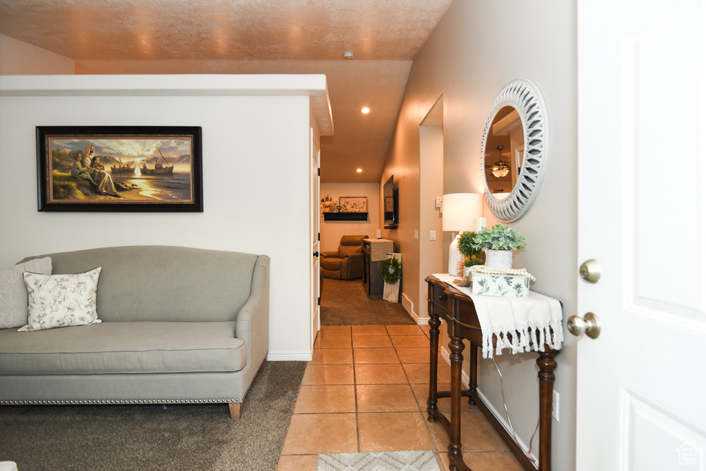Living area with light tile patterned floors, recessed lighting, baseboards, and light colored carpet