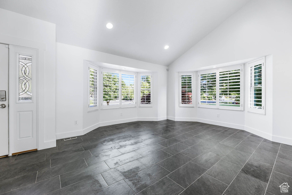Unfurnished room with recessed lighting, baseboards, and high vaulted ceiling