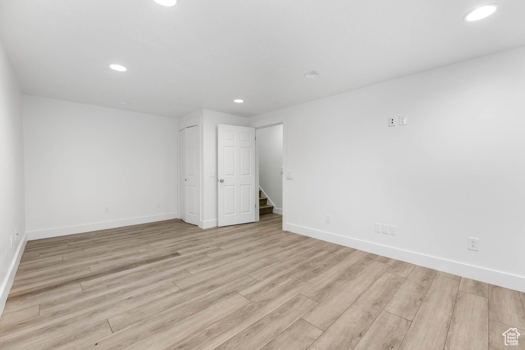 Empty room featuring baseboards, wood finished floors, and recessed lighting