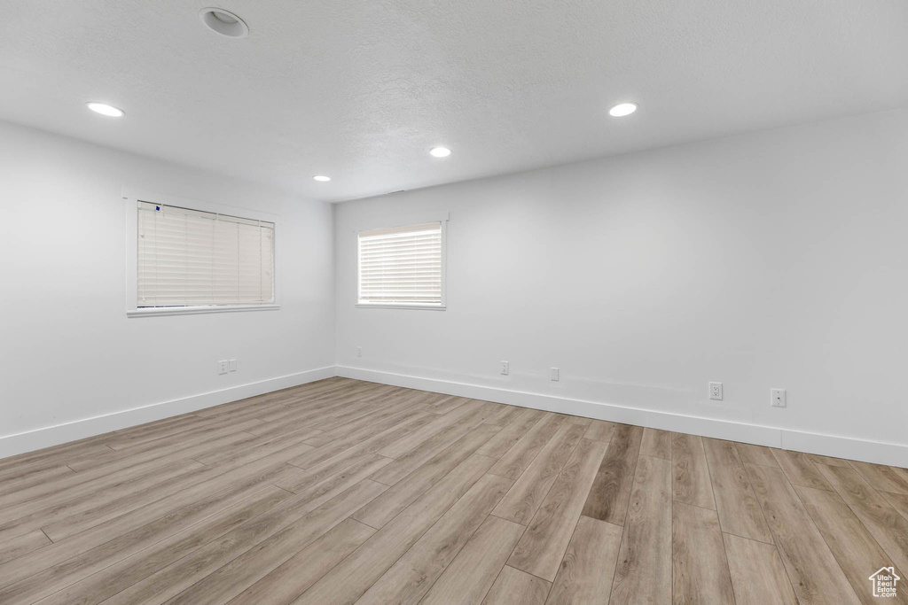 Spare room with light wood finished floors, baseboards, and recessed lighting