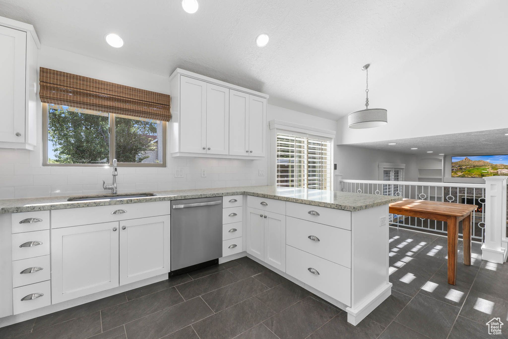 Kitchen featuring dishwasher, a sink, a peninsula, white cabinetry, and recessed lighting