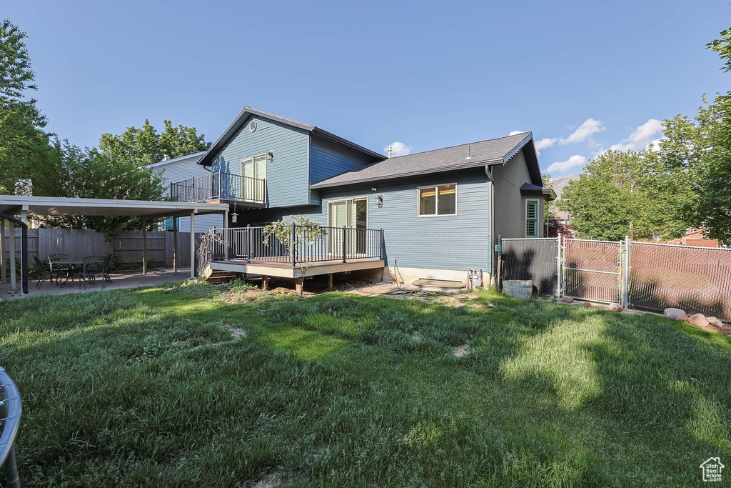 Rear view of house featuring a gate, a deck, and a patio