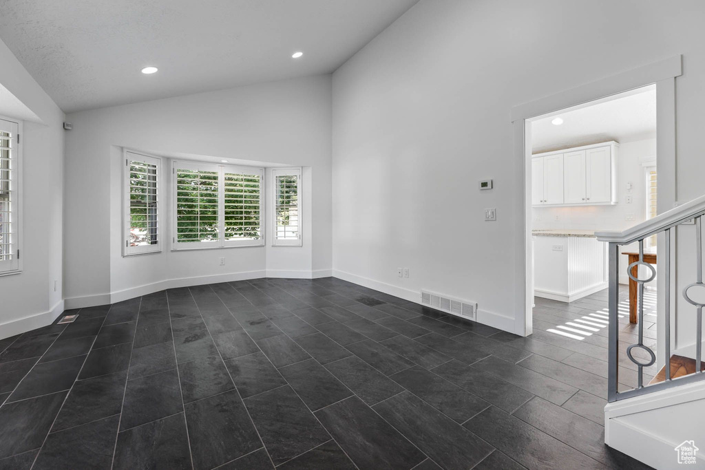 Unfurnished room with vaulted ceiling, recessed lighting, and baseboards