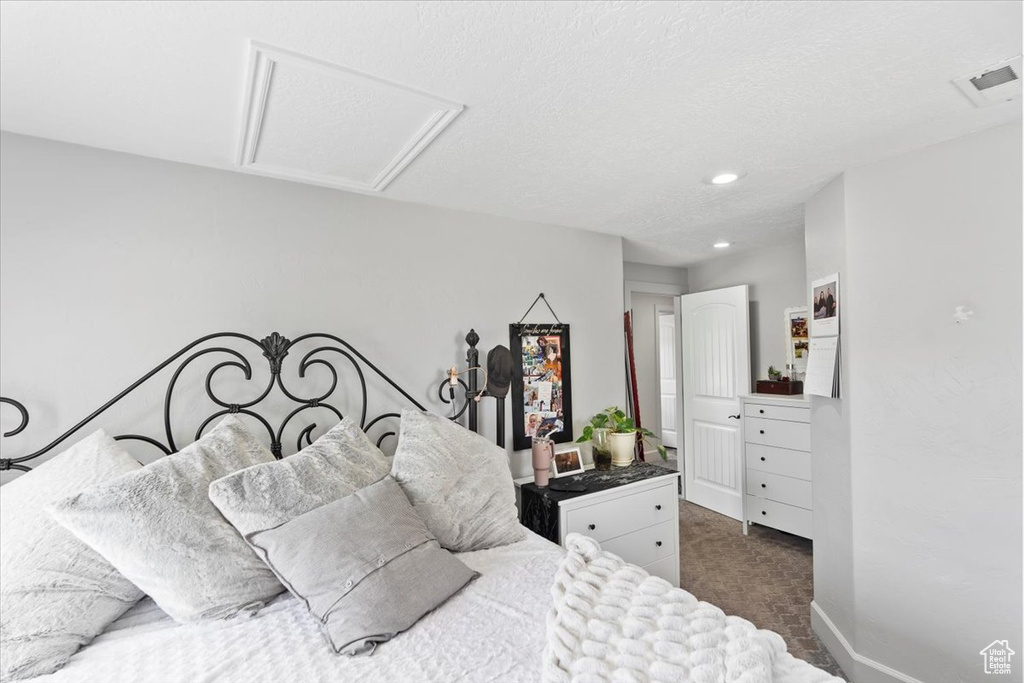 Bedroom featuring dark colored carpet, attic access, and recessed lighting