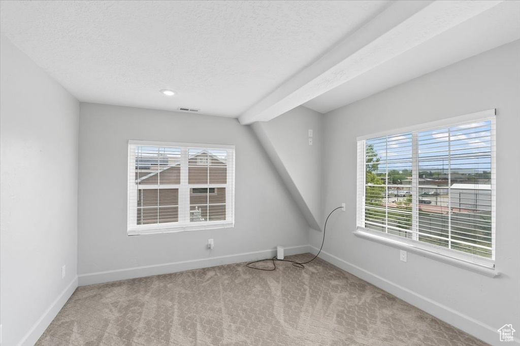 Carpeted empty room with baseboards and a textured ceiling