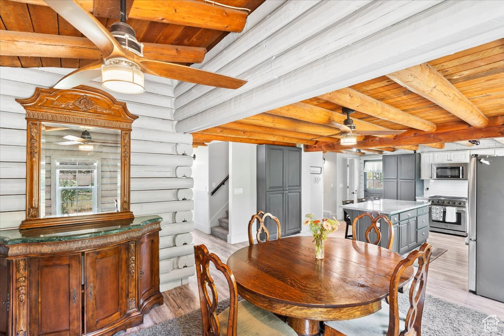 Dining area featuring ceiling fan, wood ceiling with exposed beams, light wood-type flooring, and stairway