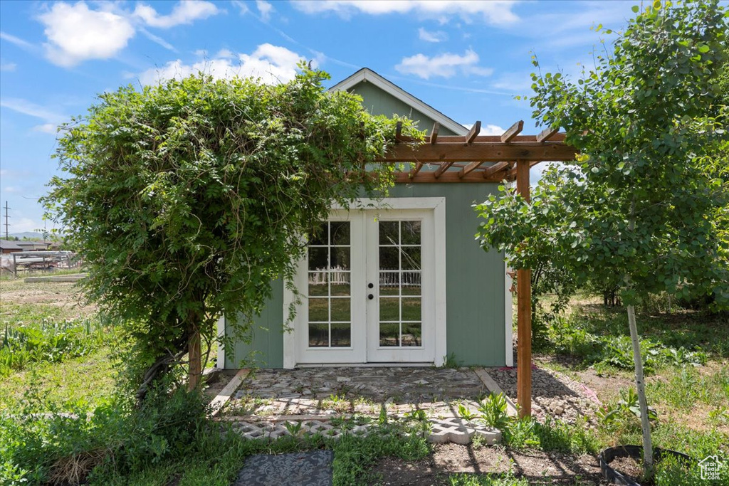 View of outbuilding with french doors and a pergola