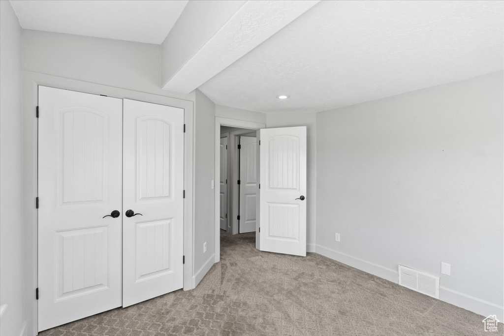 Unfurnished bedroom featuring a closet, carpet floors, baseboards, and recessed lighting