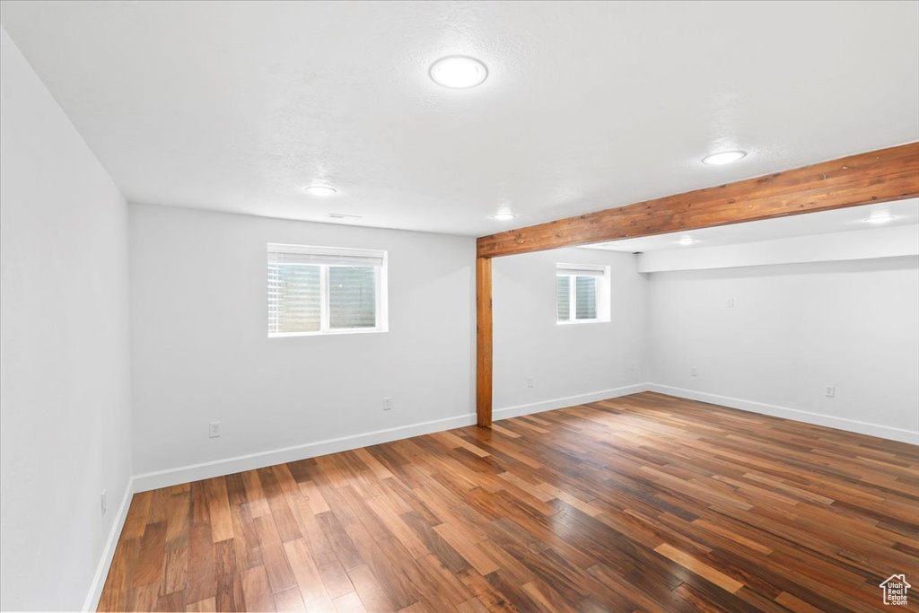 Basement featuring healthy amount of natural light, wood finished floors, baseboards, and recessed lighting