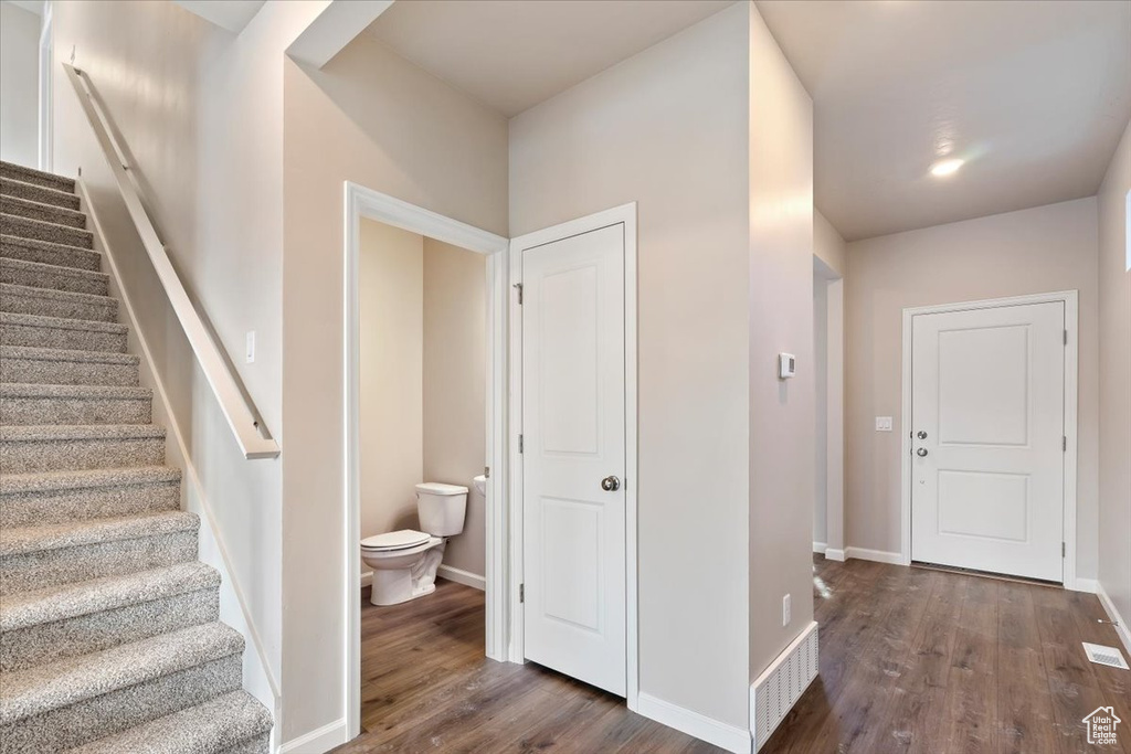 Foyer entrance with wood finished floors, stairs, and baseboards