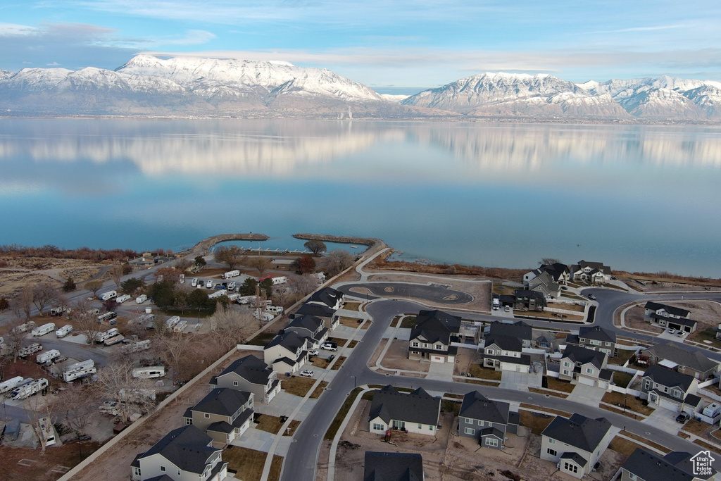 Aerial view of property and surrounding area featuring a water and mountain view and nearby suburban area