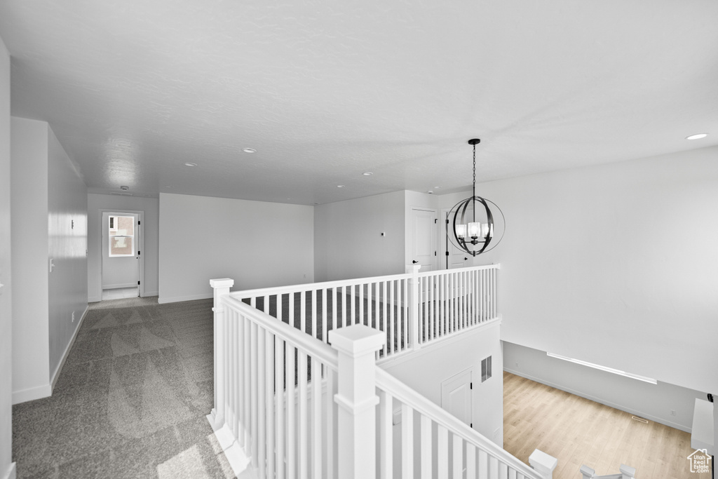 Hall featuring a chandelier, baseboards, an upstairs landing, recessed lighting, and carpet flooring