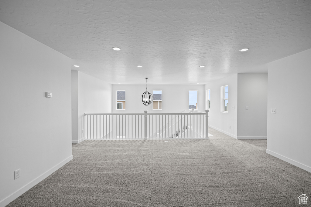 Empty room with recessed lighting, carpet, baseboards, a chandelier, and a textured ceiling