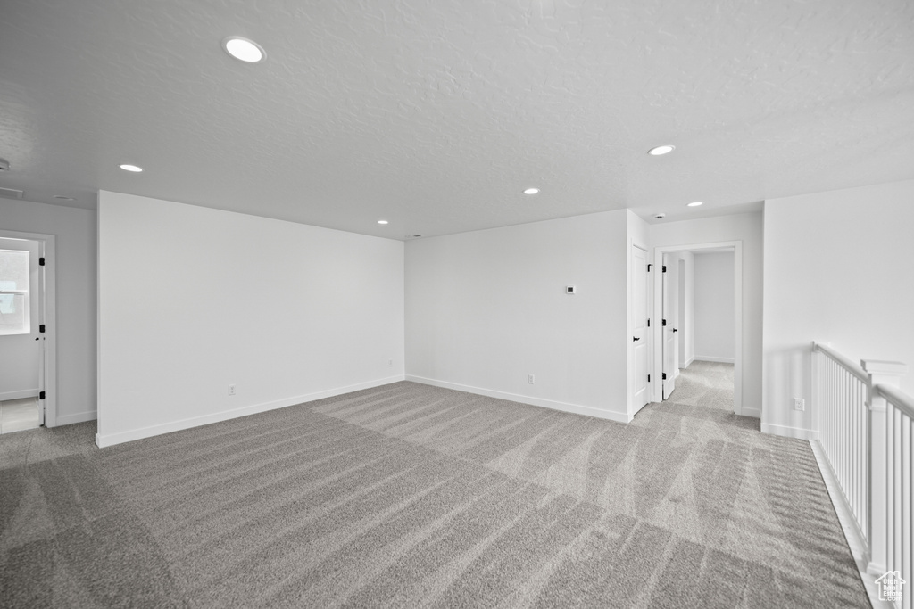 Carpeted empty room featuring recessed lighting, a textured ceiling, and baseboards
