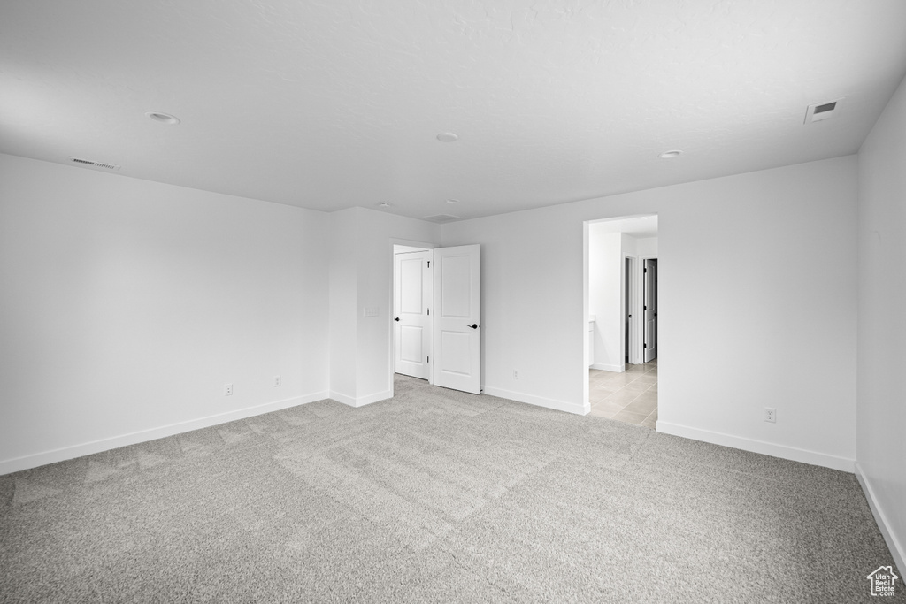 Spare room featuring carpet flooring, baseboards, and recessed lighting