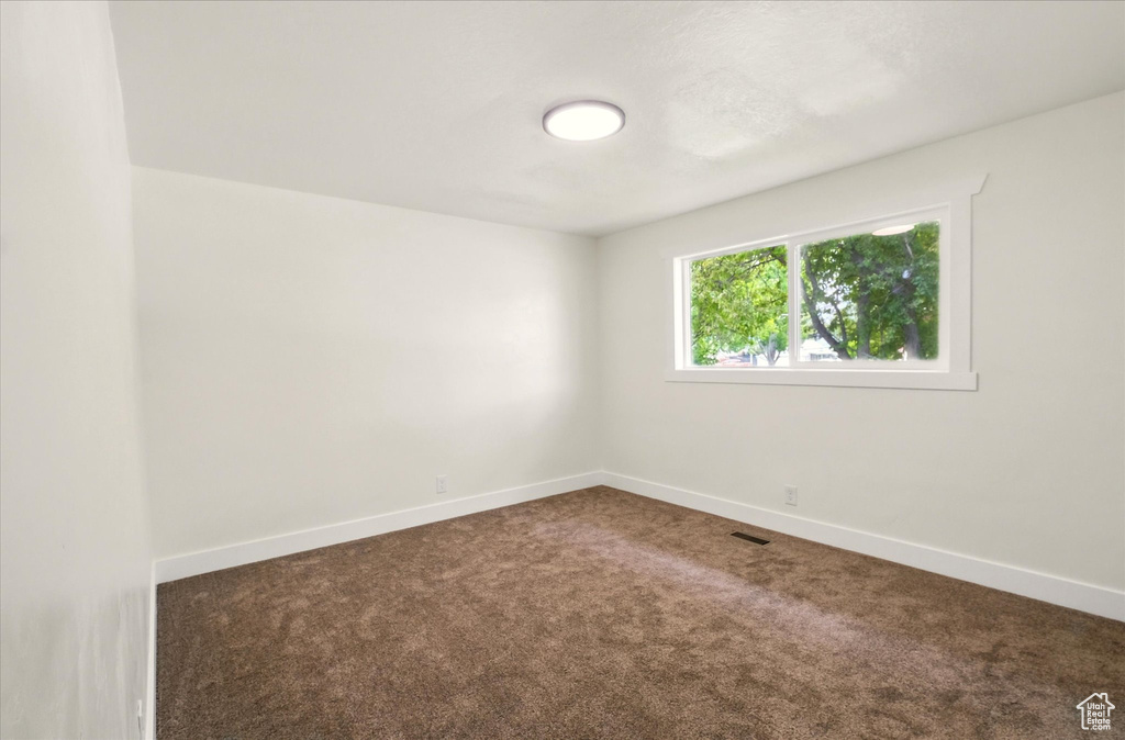 Spare room featuring carpet floors and baseboards