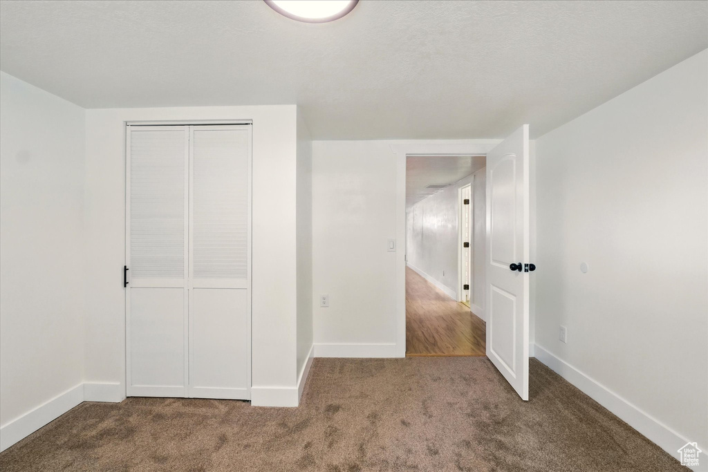 Unfurnished bedroom with carpet, baseboards, and a closet