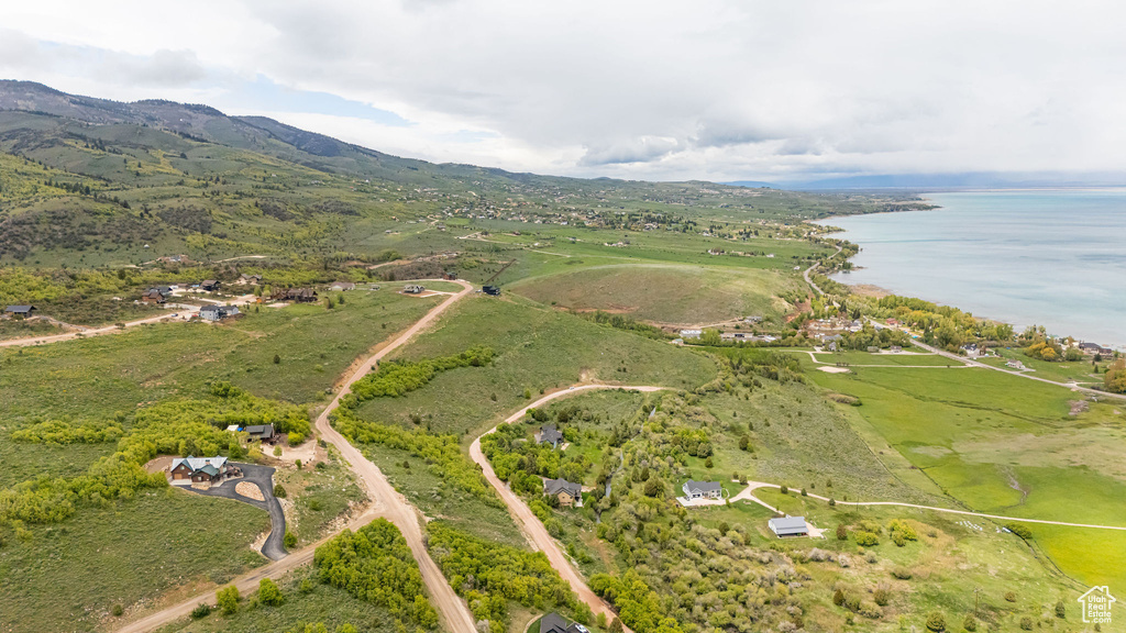 Aerial view of property and surrounding area featuring a water and mountain view