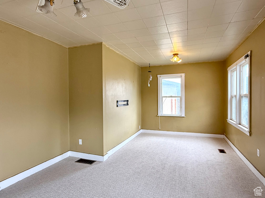Empty room with carpet, healthy amount of natural light, and baseboards