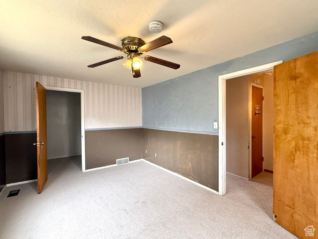 Unfurnished room featuring ceiling fan, a smoke detector, carpet flooring, and baseboards