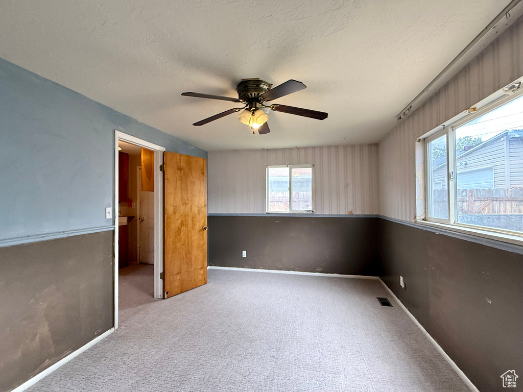 Unfurnished bedroom with carpet, baseboards, a ceiling fan, and a textured ceiling