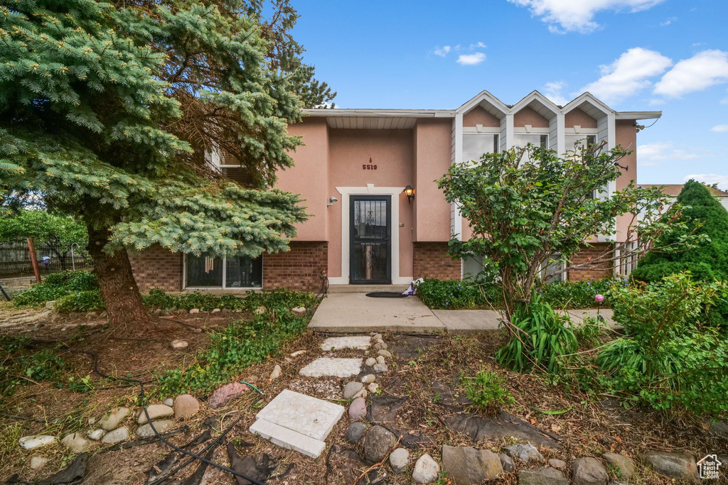View of front of house featuring stucco siding and brick siding
