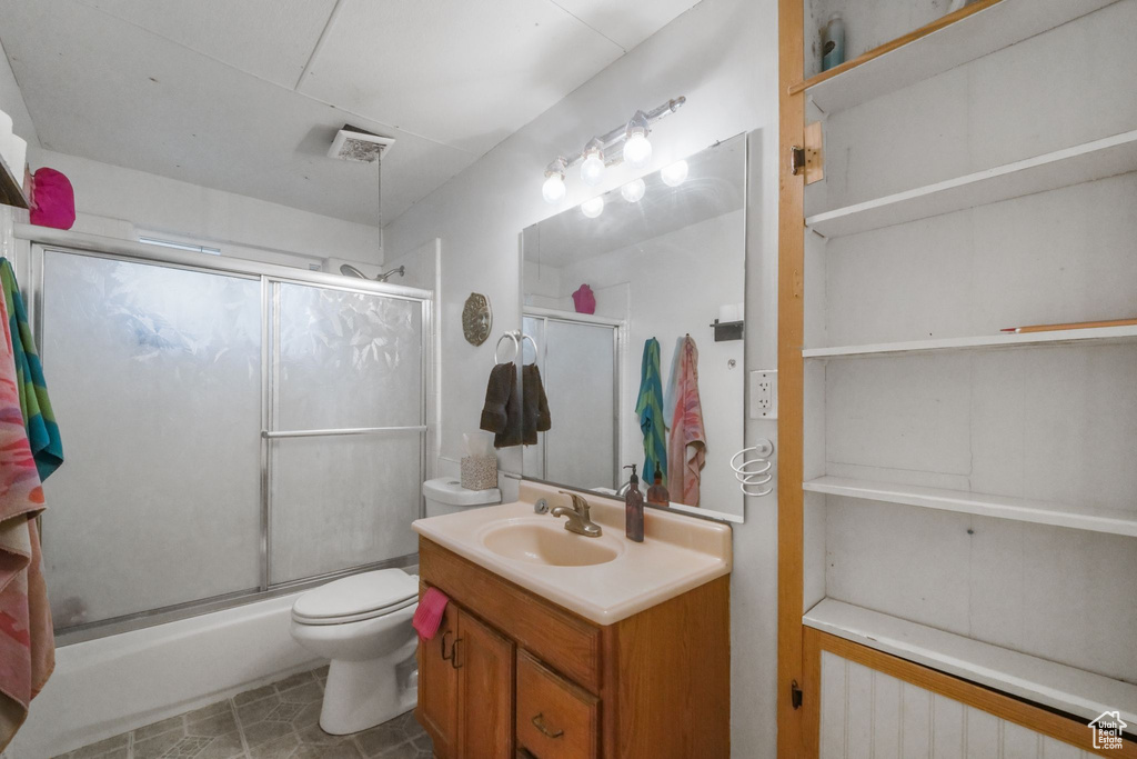 Bathroom featuring an enclosed shower, toilet, vanity, and tile patterned floors
