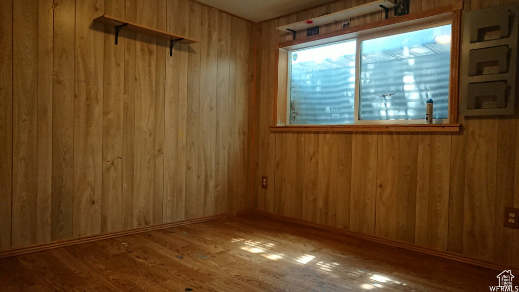 Empty room featuring wooden walls and wood finished floors