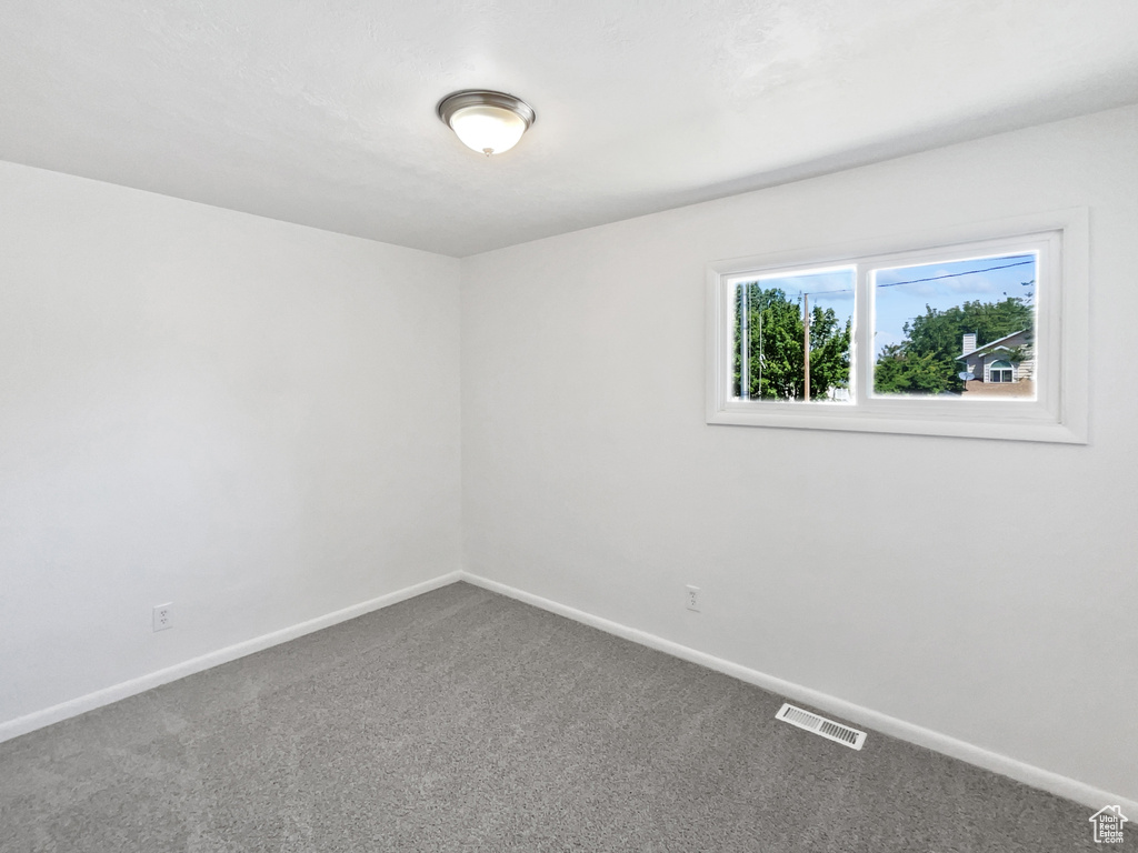 Empty room featuring carpet floors and baseboards