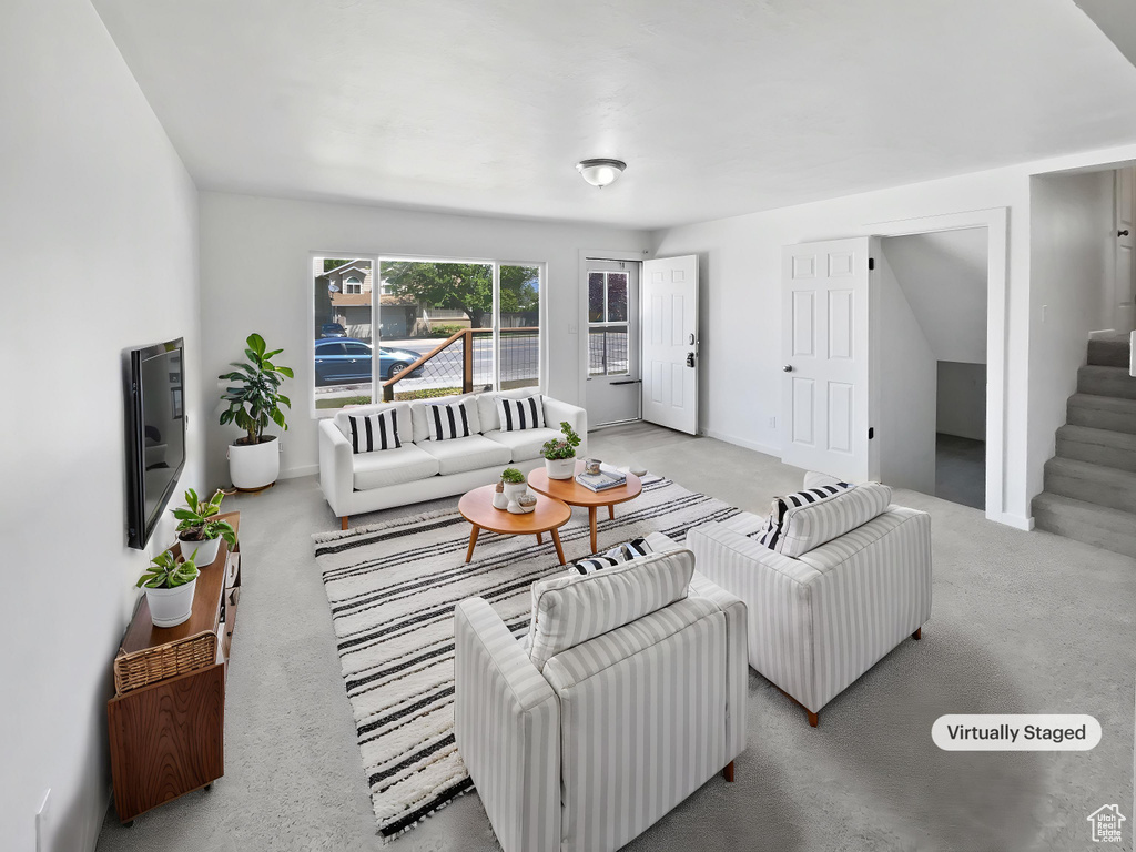 Living room featuring stairs and carpet floors