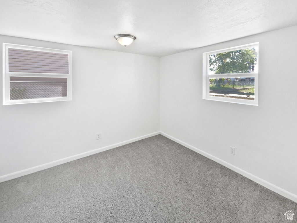 Empty room featuring baseboards and carpet floors