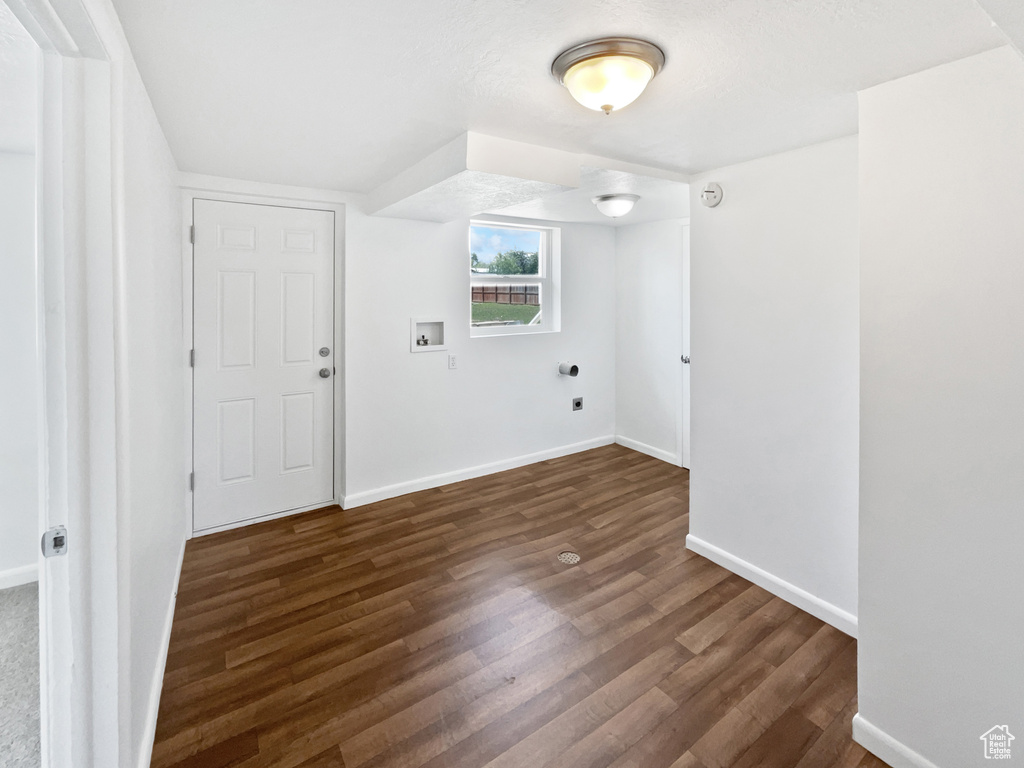 Additional living space with dark wood finished floors and baseboards