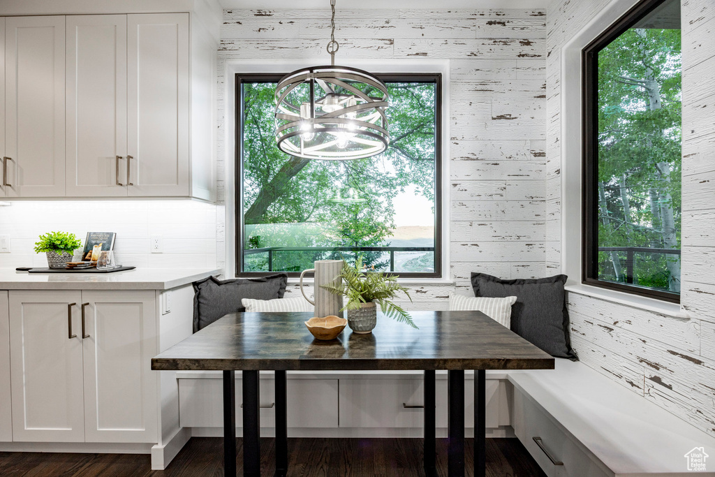 Dining space featuring breakfast area, a chandelier, plenty of natural light, and dark wood-style floors