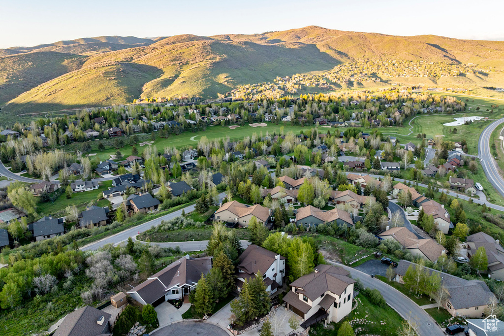 Aerial perspective of suburban area with a mountain backdrop and a golf club