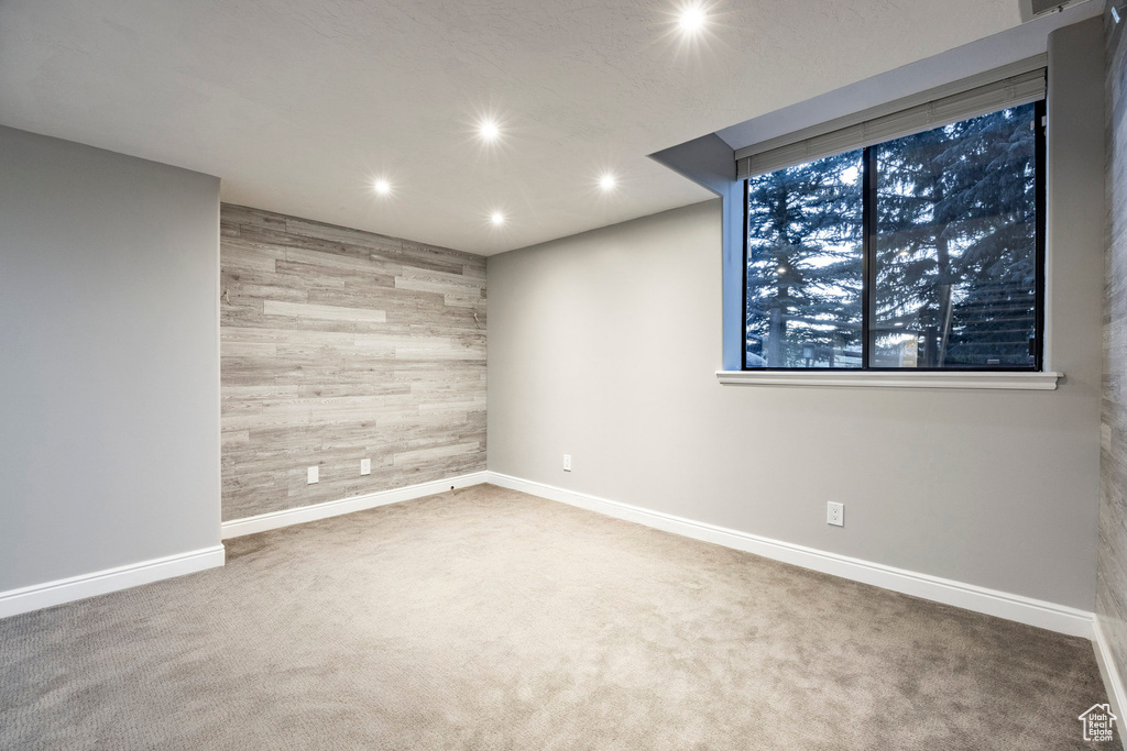Unfurnished room with wooden walls, recessed lighting, carpet floors, and baseboards