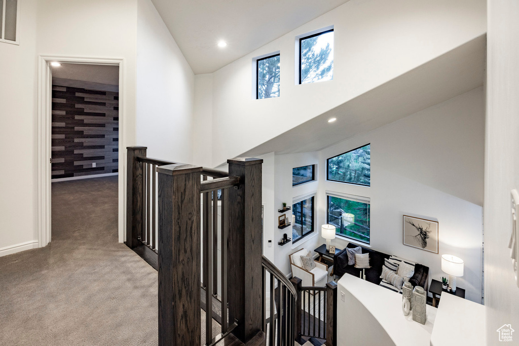 Hall featuring an upstairs landing, high vaulted ceiling, carpet, recessed lighting, and baseboards