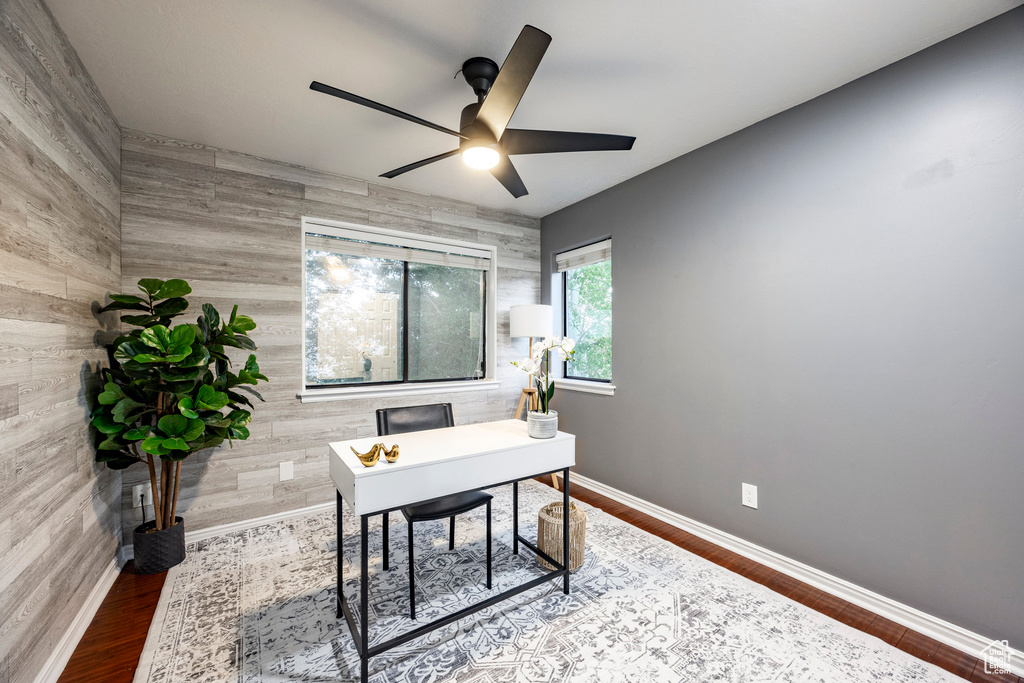 Home office featuring a ceiling fan, baseboards, and wood finished floors